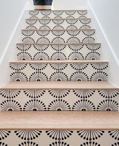 the stairs are decorated with black and white designs on them, as well as a basket