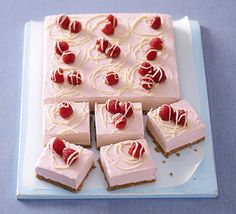 there are many small pieces of cake on the plate with raspberry toppings