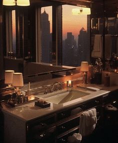 a bathroom with a double sink and large window overlooking the city at sunset or dawn