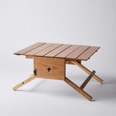 a wooden table that is sitting on top of a white surface with no one around it