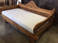 a wooden bench with white cushions in a room