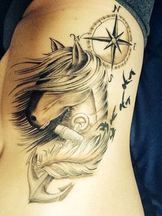 a woman's stomach with a horse and compass tattoo on it