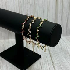 Elevate your style with this delicate flower bracelet featuring stunning CZ stones in red, green, and clear hues. Perfect for adding a festive touch to any outfit! 🌸 #delicatebracelet #czjewelry #flowerbracelet #handmadejewelry #festiveaccessories #jewelrylovers Red Ruby Bracelet, Leaf Bracelet, Christmas Accessories, Cz Jewelry, Bridal Bracelet, Clear Stone, Gold Plated Bracelets, Delicate Jewelry, Flower Bracelet