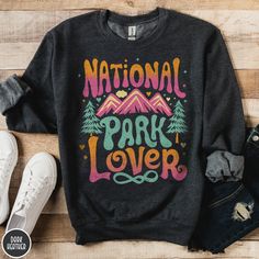 "The perfect gift for the hiker, camper, or outdoor lover in your life! Celebrate our US National Parks with this one of a kind retro vintage inspired National Park Lover Sweatshirt from Triangle Threads. Perfect for hiking on the trail our relaxing on the couch, this Gildan 18000 50/50 blend crewneck has an awesome look while remaining extremely COMFY and VERY soft to the touch. Get yours today and celebrate our nation's greatest treasure, our National Parks, in style! * Product Highlights * Ideal for any situation, this Gildan 18000 heavy blend crewneck sweatshirt is pure comfort. Made from an extremely soft 50/50 polyester and cotton blend, this combination helps keep you warm and comfortable. The collar features a ribbed knitting, and it retains its shape after washing. There are NO it Cotton Sweatshirt With Letter Print For Outdoor Activities, Cotton Sweatshirt With Letter Print For Outdoor, Cotton Letter Print Sweatshirt For Outdoor Activities, Casual Sweatshirt With Screen Print For Outdoor Activities, Long Sleeve T-shirt With Letter Print For Outdoor Activities, Long Sleeve Letter Print T-shirt For Outdoor Activities, Long Sleeve T-shirt With Letter Print For Outdoor, Long Sleeve Letter Print T-shirt For Outdoor, Fall Camping T-shirt With Letter Print