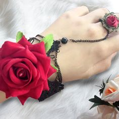 Design Concept Enhance your ensemble with this beautifully crafted Gothic Rose Ring Bracelet. Perfect for adding a touch of vintage charm to any outfit, this unique piece is designed to make a statement. This bracelet features a striking red rose centerpiece, symbolizing timeless elegance and love. The intricate black chain and lace details add a Victorian flair, making it perfect for themed events or everyday wear. Made from high-quality materials, this rose ring bracelet is designed for durabi Rose Metal Jewelry For Party, Wedding Jewelry With Rose Design In Metal, Victorian Rose Gold Bracelets As Gift, Metal Rose Design Jewelry For Wedding, Victorian Rose Gold Bracelets Gift, Vintage Metal Jewelry With Rose Design, Vintage Rose Design Jewelry For Valentine's Day, Gothic Rose Colored Jewelry For Gift, Vintage Rose Jewelry For Valentine's Day