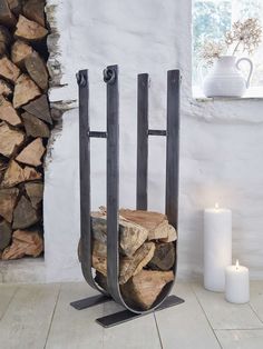 a stack of firewood sitting next to a white candle and some wood stacked on top of each other