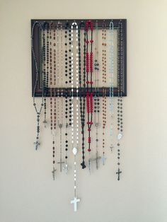 a wall hanging with beads and crosses on it