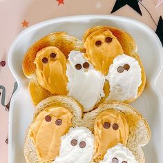 toasted bread with marshmallows and ghost faces on them in a white dish