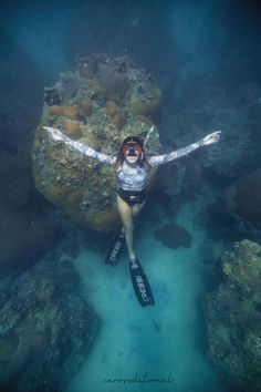 a woman is swimming in the water with her scuba gear