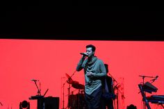 a man standing on top of a stage holding a microphone