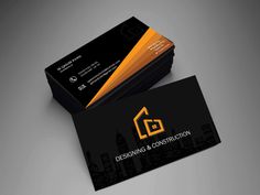 a black and yellow business card with an orange house logo on the front, sitting on top of a gray surface