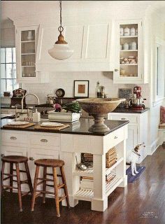 a kitchen with white cabinets and wooden floors