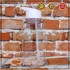 a clear glass jar with a white lid sitting next to a brick wall