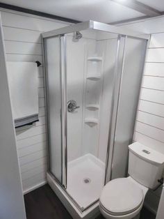 a white toilet sitting next to a walk in shower