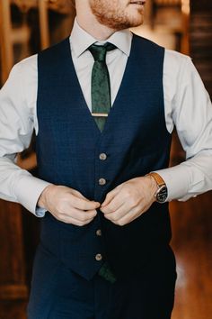 a man wearing a suit and tie with his hands in his pockets