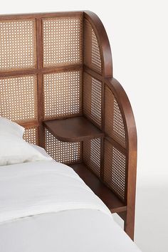 a bed with a wooden headboard and white sheets