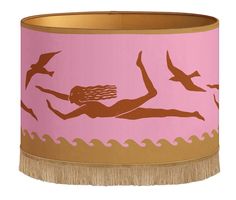 a pink and gold lamp shade with an image of a woman swimming in the ocean