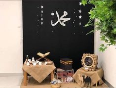 the table is set up for an event with items on it and decorations hanging from the wall