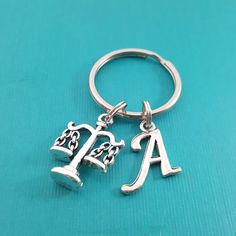 This key chain is handcrafted featuring a detailed silver Justice scales charm and an silver plated script initial of your choice for a personalized touch. Attached to a Stainless steel key ring, one inch in diameter. ✦ Mobile Shoppers < swipe > to see all photos ✦❀ Gift packaging included with every order! ❀♥ Customize this key chain! ♥ Add additional initials, charms, birthstones and more here:https://www.etsy.com/shop/DaisyandFox?section_id=17074779See more key chains here:https://www.e Personalized Silver Keychain For Personal Use, Metal Keychains With Charms For Gifts, Metal Charms Keychains For Gift, Metal Keychains With Charms As Gifts, Metal Charms Keychains As Gifts, Personalized Silver Keychain, Engraved Silver Charms For Customizable Gifts, Personalized Engraved Silver Charms, Silver Metal Jewelry With Initials