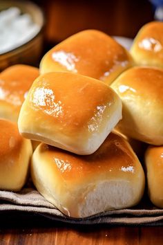 several rolls stacked on top of each other in front of a bowl of dipping sauce