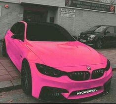 a pink car parked in front of a building