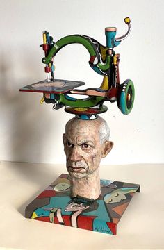 a sculpture of a man's head with multiple objects on top of his head