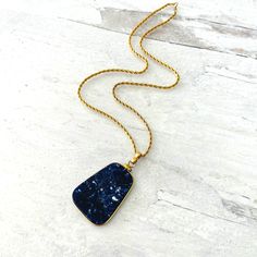 This is a gorgeous natural large sodalite slice gold filled pendant necklace. Sodalite is a dark blue stone with white inclusion, often confused with lapis lazuli. The color is slightly lighter and the texture is not as smooth in lapis. The stone is hand cut in a trapezoid shape with rounded corners. The custom setting is made from a thick gauge wire and finished with a screw type assembly right below the bail. The bail is also custom-made. The pendant is very well made. The stone is expertly cu Trapezoid Shape, Maker’s Mark, Rope Chain, Blue Stone, Rounded Corners, Lapis Lazuli, Gold Filled, Screw, Dark Blue