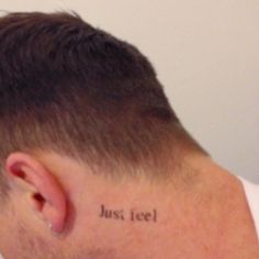 the back of a man's head with words written on his left side neck