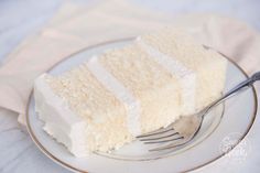 a piece of white cake on a plate with a fork and napkin next to it