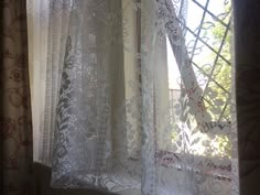 an open window with white lace on it