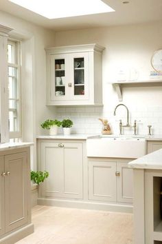 a kitchen with white cabinets and wooden floors