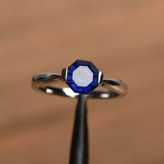 a ring with a blue and white diamond on it