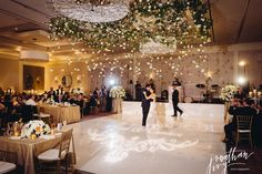 two people are dancing on the dance floor in front of an audience at a wedding