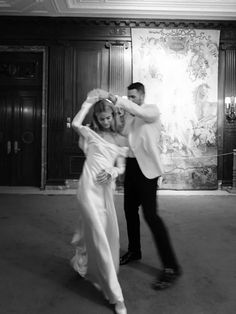 a man and woman are dancing in a room