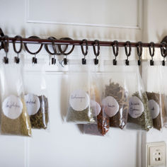 five bags of spices hanging on a wall