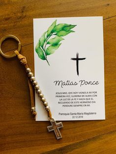 a keychain with a cross on it sitting next to a card that says matas ponce