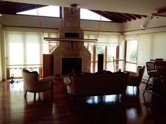 a living room filled with furniture and a fire place in the middle of an open floor plan