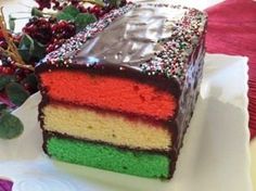 a piece of cake with chocolate frosting and sprinkles on it sitting on a plate