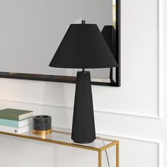 a black lamp sitting on top of a table next to a mirror