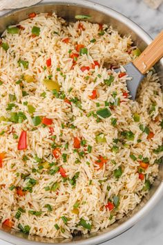 a pan filled with rice and vegetables on top of a table