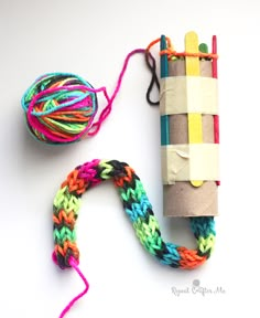 a roll of yarn next to a crochet loom