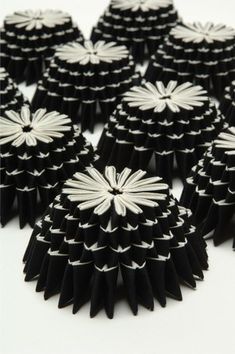 several black and white paper flowers on a white surface