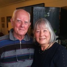 an older man and woman standing next to each other