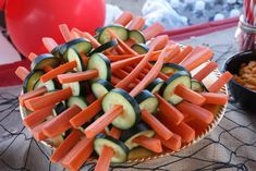 a platter filled with cucumbers, carrots and pretzel sticks