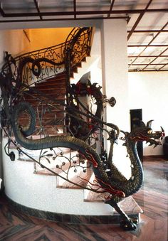 a spiral staircase with dragon statues on it