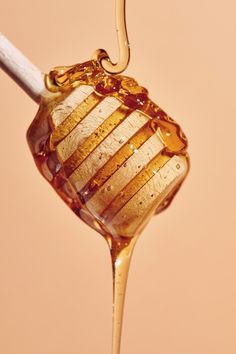 honey dripping from a spoon into liquid