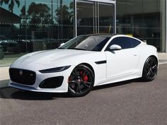 a white sports car parked in front of a building