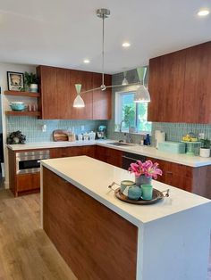 a large kitchen with wooden cabinets and white counter tops, along with an island in the middle