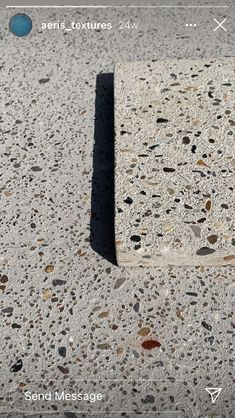 a close up of a cement surface with small rocks and pebbles on the ground below