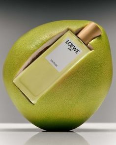 a green apple with a perfume bottle in it